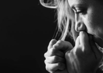 A pic of a woman with her hands to mouth looking worried